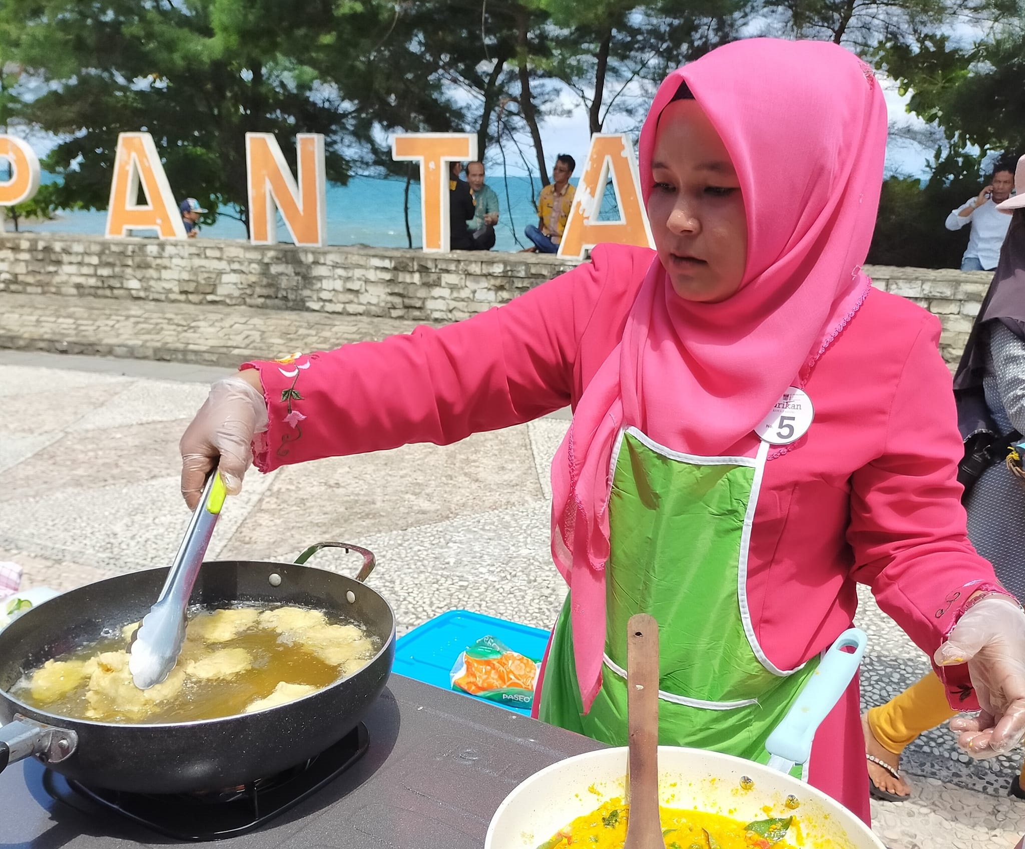 Salah seorang peserta lomba Masak Serba Ikan antusias mengikuti perlombaan, Minggu (5/5) di Gelanggang Pantai Purus Padang. (FACEBOOK DISKOMINFO PADANG)
