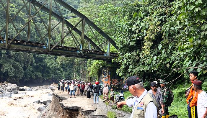 Jalan utama penghubung Padang - Bukittinggi putus total di beberapa titik akibat tergerus luapan air sungai.