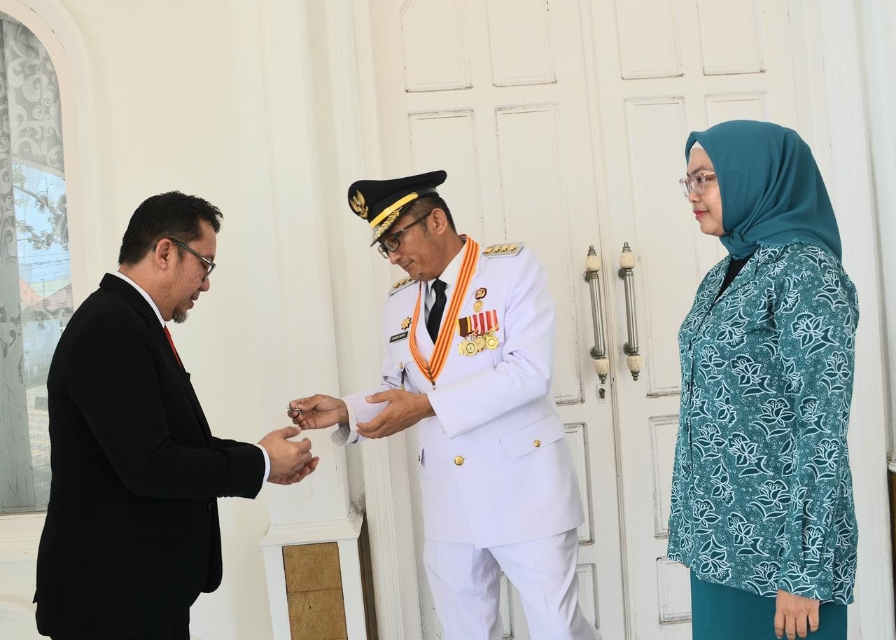 Wako Padang Hendri Septa menyerahkan kunci rumah dinas kepada Kabag Umum Setko Padang Harry Krisna Mulia, kemarin. (DOK PROKOPIM PADANG)