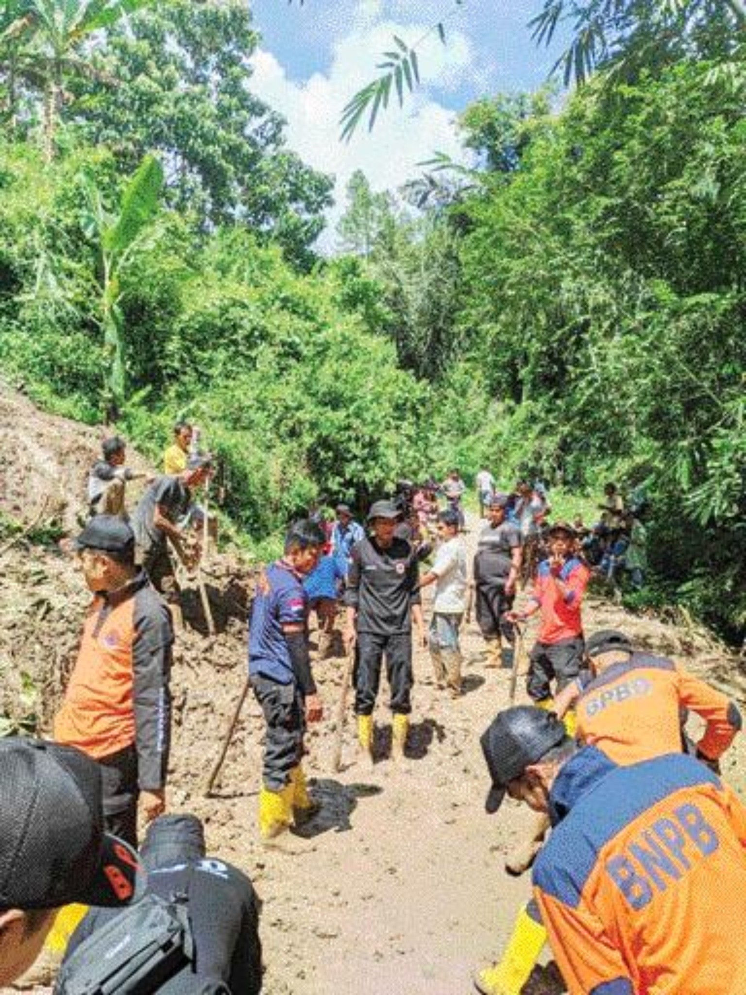 ATASI DAMPAK BENCANA: Personel dan dibantu warga bergotong royong membersihkan material longsor di Kecamatan Gunuang, kemarin.(DOKUMEN BPBD UNTUK PADEK)