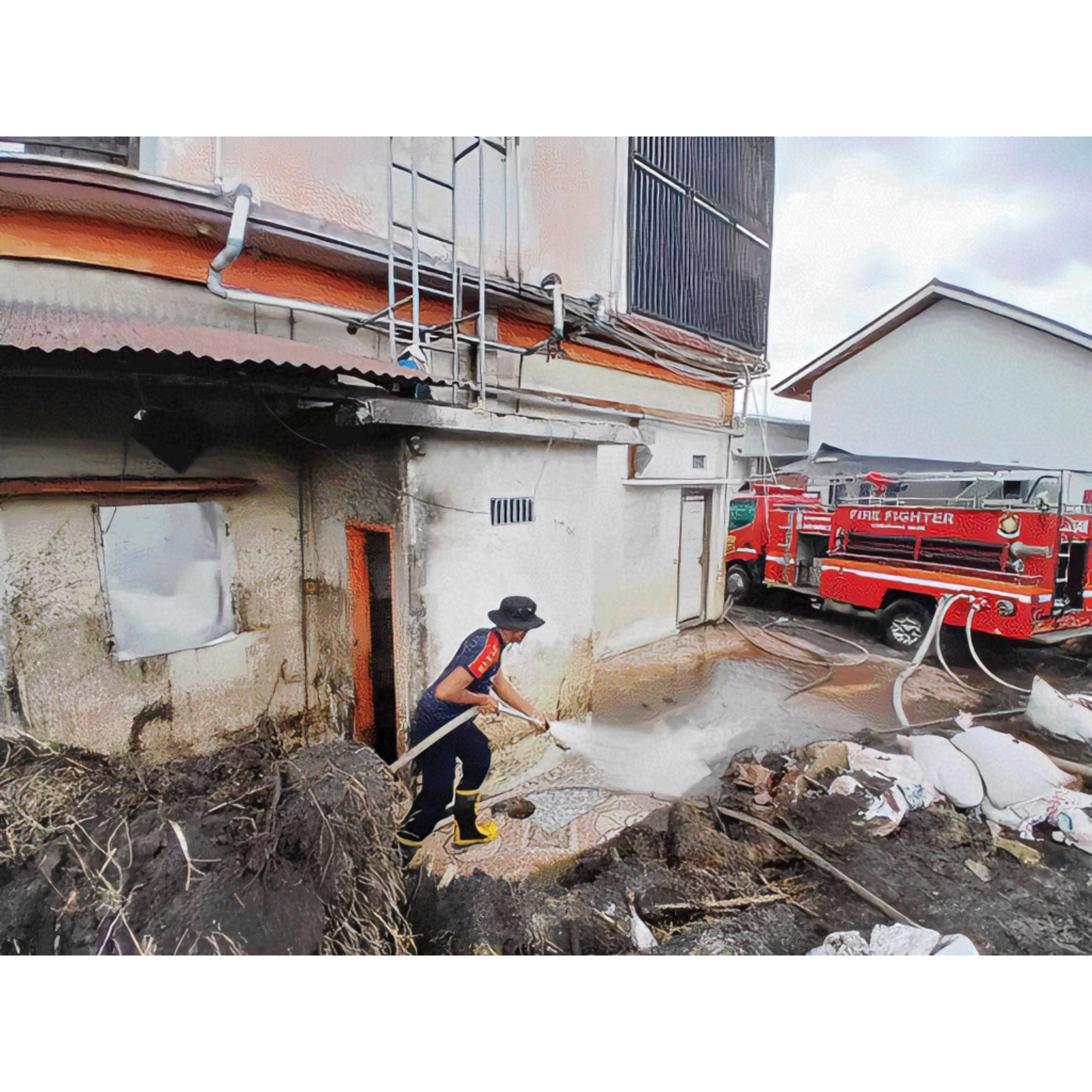 BERJIBAKU: Personel Damkar Agam berjibaku membersihkan sisa material banjir di rumah warga yang yang terdampak bencana di wilayah itu, kemarin.(HUMAS PEMKAB AGAM FOR PADEK)