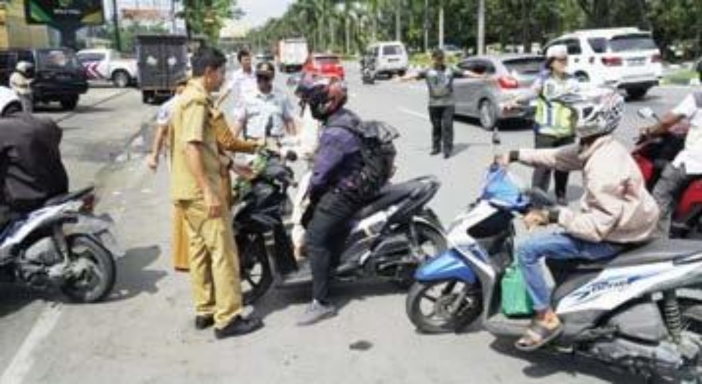 OPERASI: Bapenda Provinsi Riau, bersama Jasa Raharja, Ditlantas Polda Riau menggelar razia pajak kendaraan bermotor di Jalan Jendral Sudirman, tepat di depan bandar serai MTQ, Rabu (29/5).(DEFIZAL/RPG