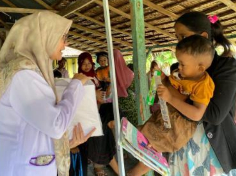 Tim Fakultas Kedokteran Gigi Unand melakukan pemeriksaan gigi anak balita dan edukasi orangtua di Posyandu Pasar Baru, Bayang, Pessel. (Foto: Dok FKG Unand)