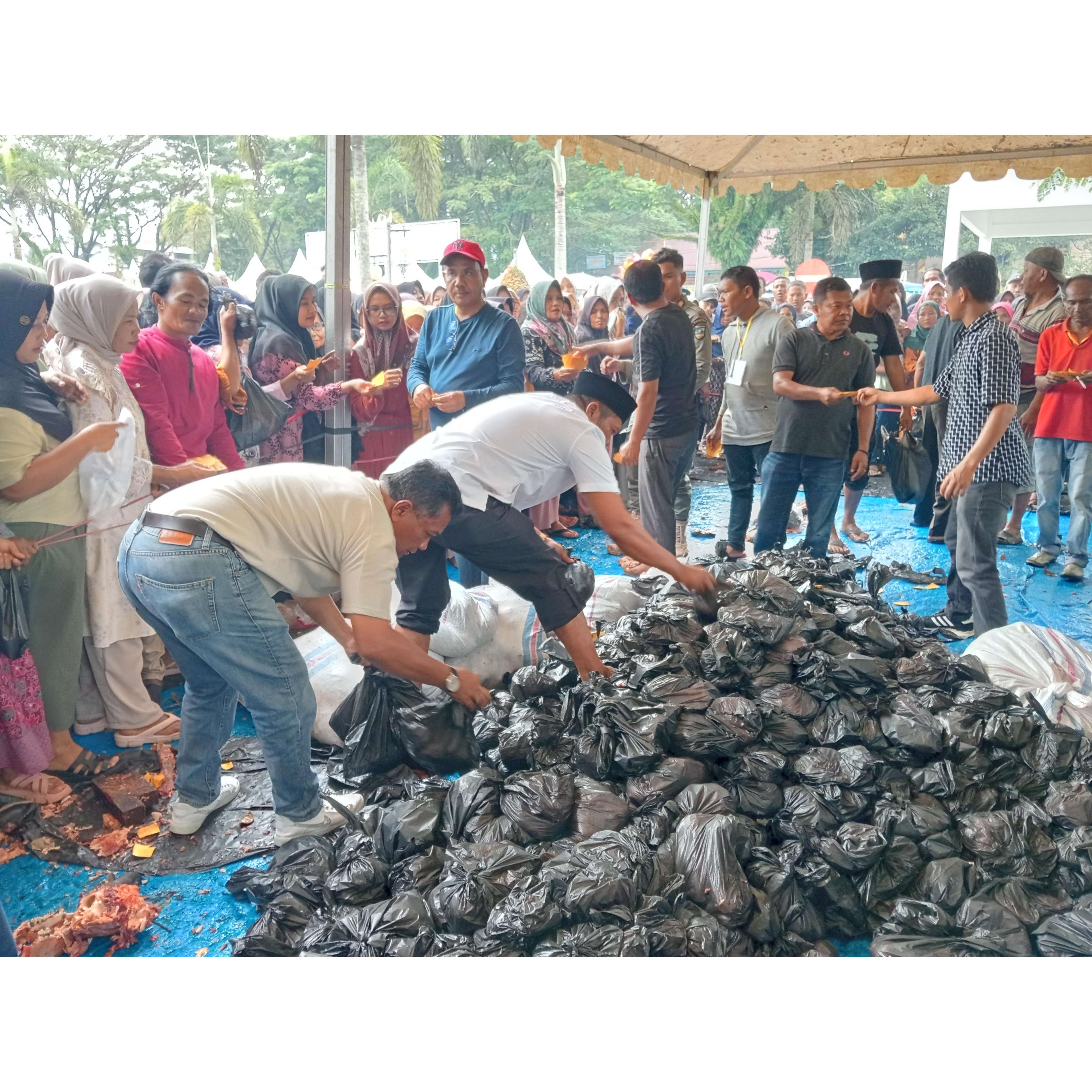 SEMANGAT BERKURBAN: Pembagian daging sapi kurban ke masyarakat oleh panitia pelaksana kurban di halaman Kantor Bupati Solsel, kemarin.(ARDI/PADEK)