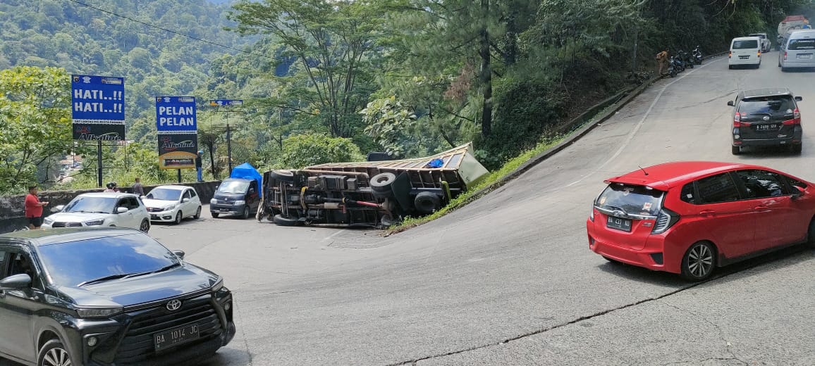 Kondisi truk terguling karena diduga tidak kuat menanjak di Panorama 1 Sitinjau Lauik, Minggu (23/6). (JEFRIMON/PADEK)