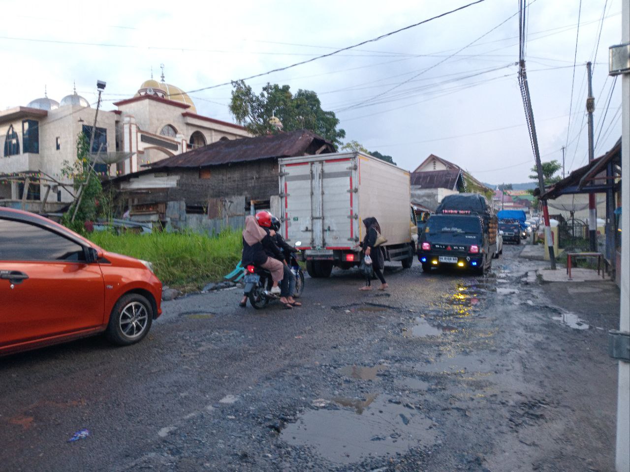 PARAH: Sejumlah pengendara esktra hati-hati saat melintasi jalanan rusak di Nagari Kototuo, Kecamatan Ampekkoto, Agam, Selasa (9/7).(RIAN AFDOL/PADANG EKSPRES)