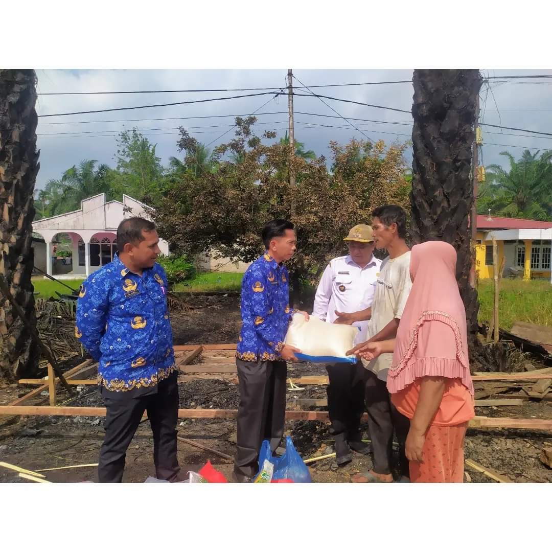 PEDULI: Kepala Dinas Sosial P3APPKB Dharmasraya Martin Effendi menyerahkan bantuan bagi korban kebakaran di Padangcandi, Nagari Sungaidareh, Pulaupunjung, kemarin.(PEMKAB DHARMASRAYA FOR PADEK)