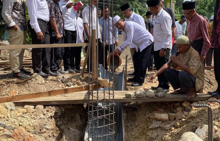 PELETAKAN BATU PERTAMA: Wakil Bupati Pasbar, Risnawanto melakukan peletakan batu pertama pembangunan Masjid Al Muhajirin di Nagari Mahakarya, Pasbar, Rabu (31/7). (PEMKAB PASBAR UNTUK PADEK)