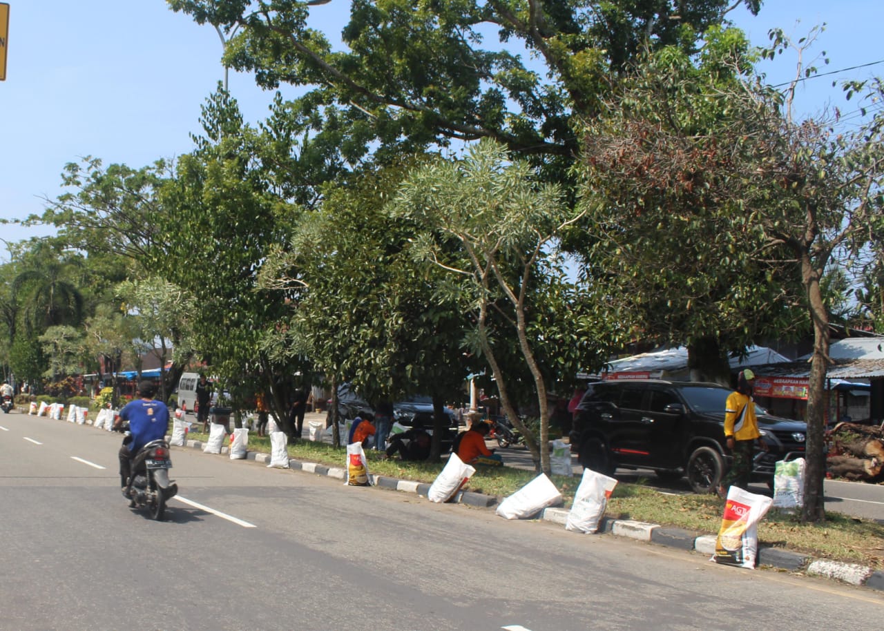 Sejumlah karung sampah berjejer di sepanjang Jalan Adinegoro, Lubukbuaya, Jumat (2/8). Karung tersebut digunakan untuk membawa rumput yang sudah dipangkas dari taman jalan. (SILVINA/PADEK)