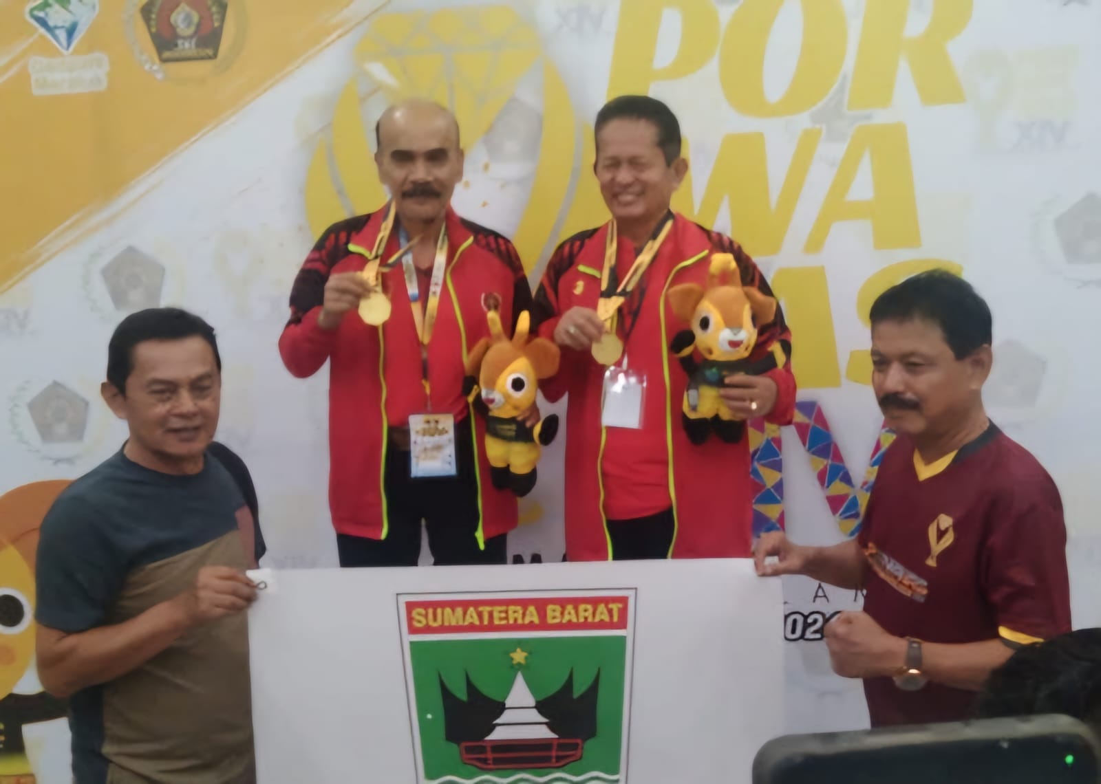 ANUGERAH: Jayusdi Effendi dan Edi Jarot, bersama Ketua PWI Sumbar Widya Navies dan Ketua SIWO Sumbar Syaiful Husein, usai pengalungan medali. (TIM PORWANAS SUMBAR)