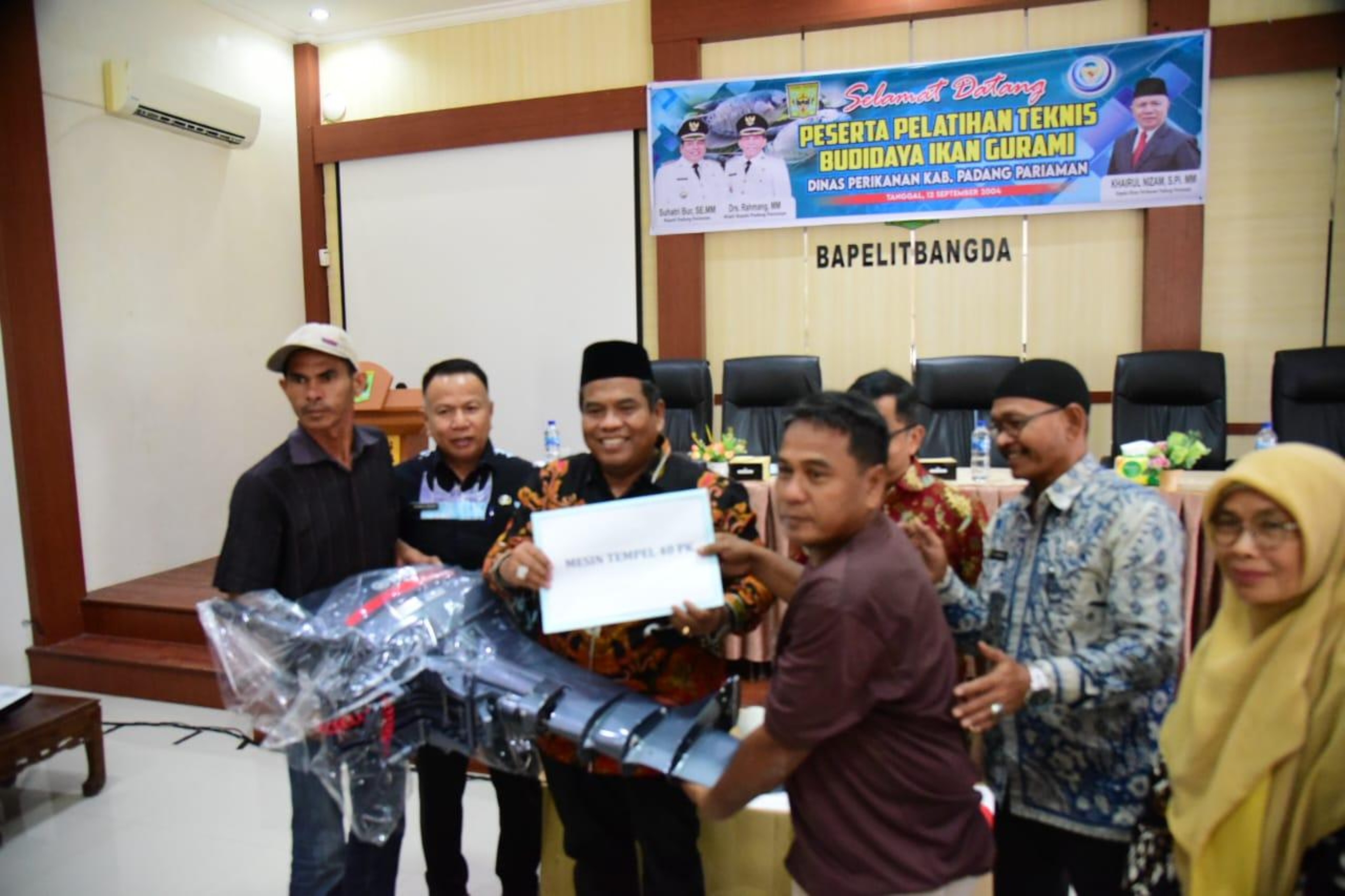 PERKUAT NELAYAN: Bupati Padangpariaman, Suhatri Bur, saat menyerahkan bantuan berupa delapan unit mesin tempel kepada KUB nelayan, kemarin. (DISKOMINFO PADANGPARIAMAN)