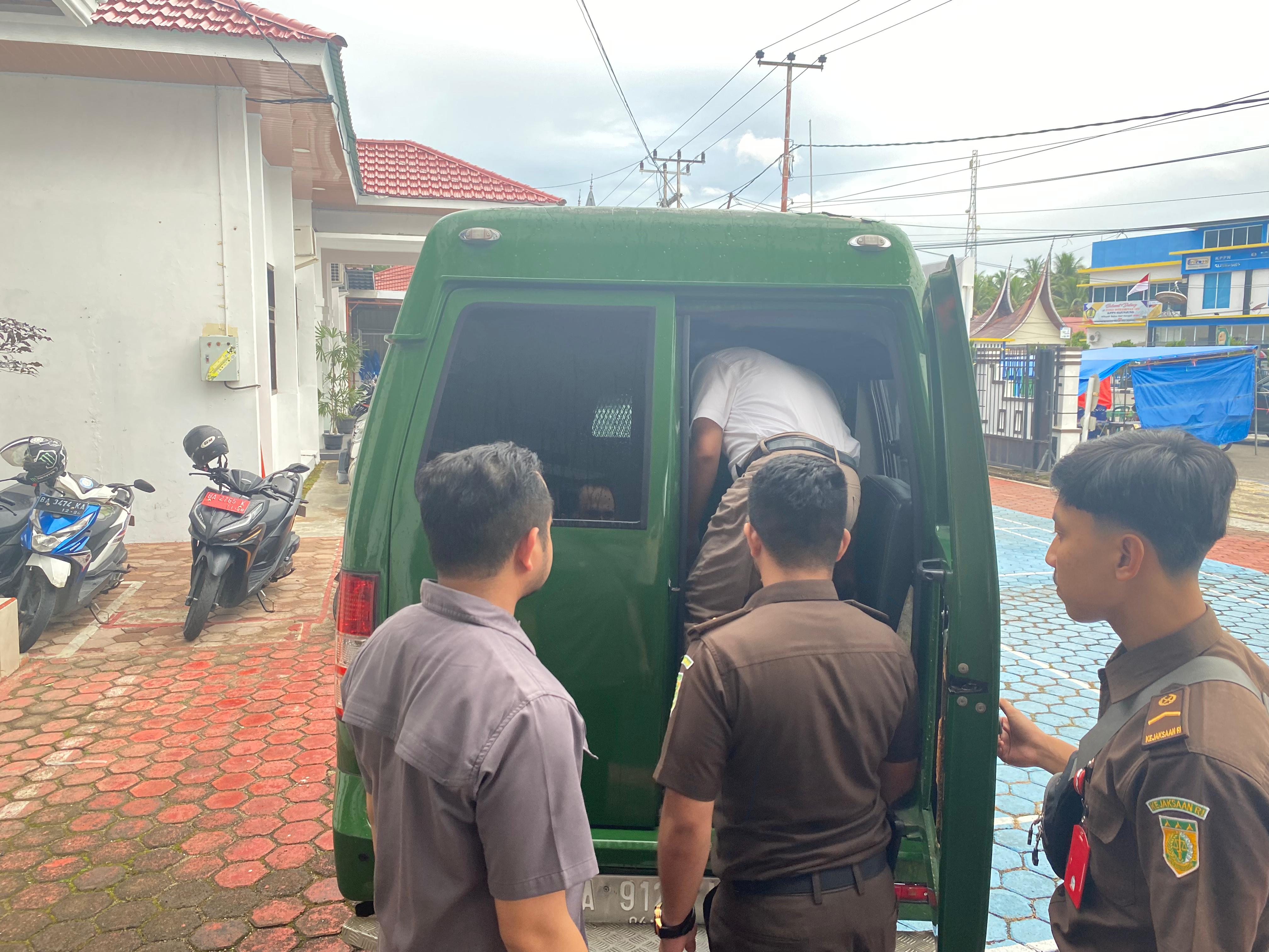 HUKUM: Mantan Ketua DPRD Sijunjung, BSI saat memasuki mobil tahanan dan dikawal petugas kejaksaan, kemarin (17/9). (KEJARI SIJUNJUNG FOR PADEK)