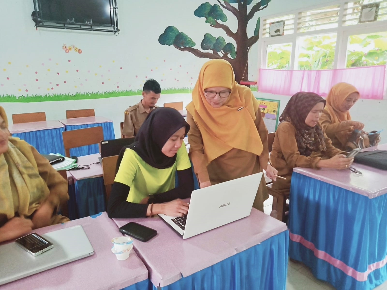 BERBAGI ILMU: Salah seorang guru UPT SDN 22 Panyalaian terlihat sedang berbagai ilmu dengan guru lainnya. (TIM LAMAN GURU)
