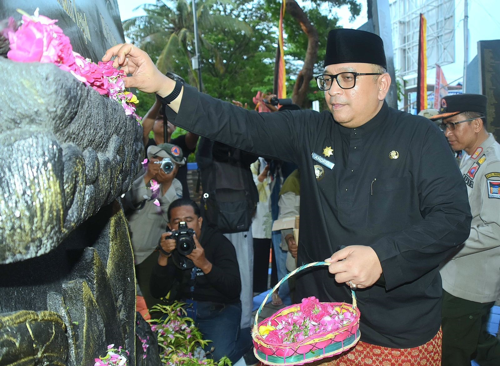 Pj Wako Padang Andree Algamar menaburkan bunga di depan Monumen Gempa Padang, Senin (30/9).