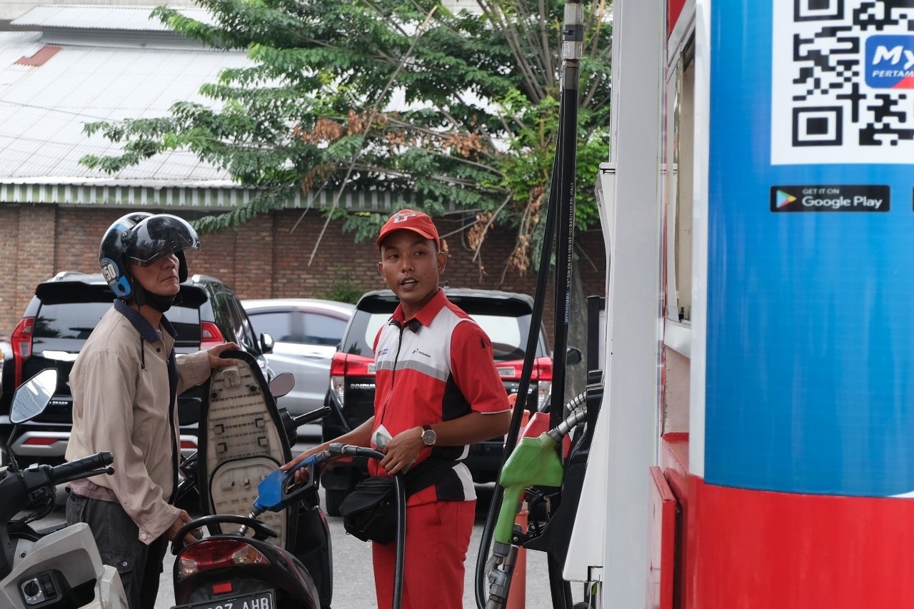 Petugas SPBU melayani pembelian BBM kepada pengendara sepeda motor.