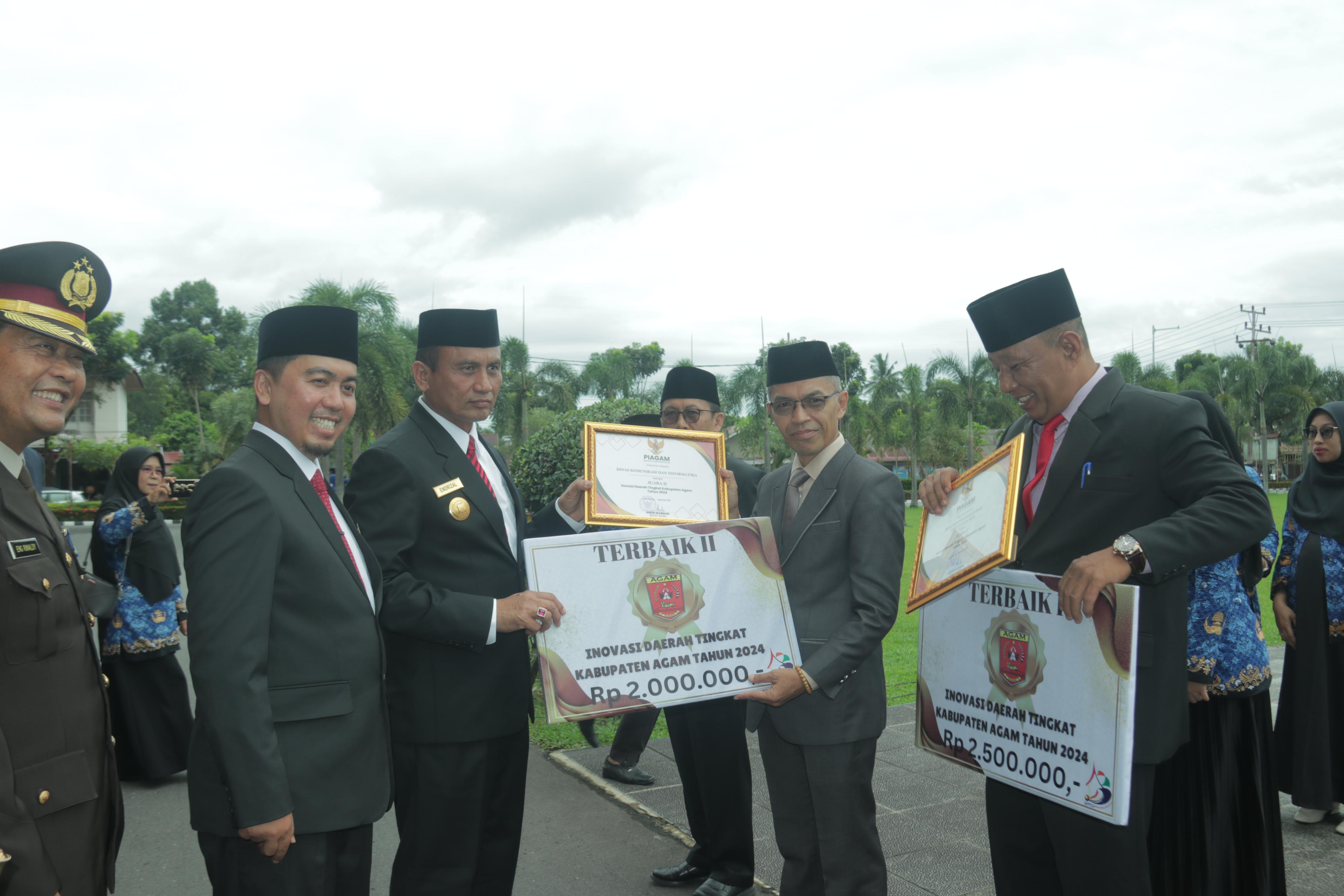 APRESIASI: Pjs Bupati Agam Endrizal menyerahkan piagam penghargaan Inovasi Daerah 2024 kepada Kadis Kominfo Syatria usai upacara peringatan Hari kesaktian Pancasila. (DISKOMINFO AGAM FOR PADEK)