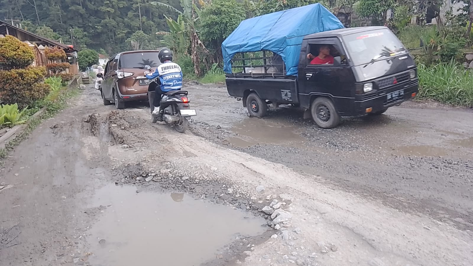 MENUNGGU JANJI PERBAIKAN: Sejumlah kendaaran melewati jalan Provinsi Sumatera Barat Payakumbuh Lintau dengan kondisi yang rusak parah, kemarin. (FIDEL/PADEK)