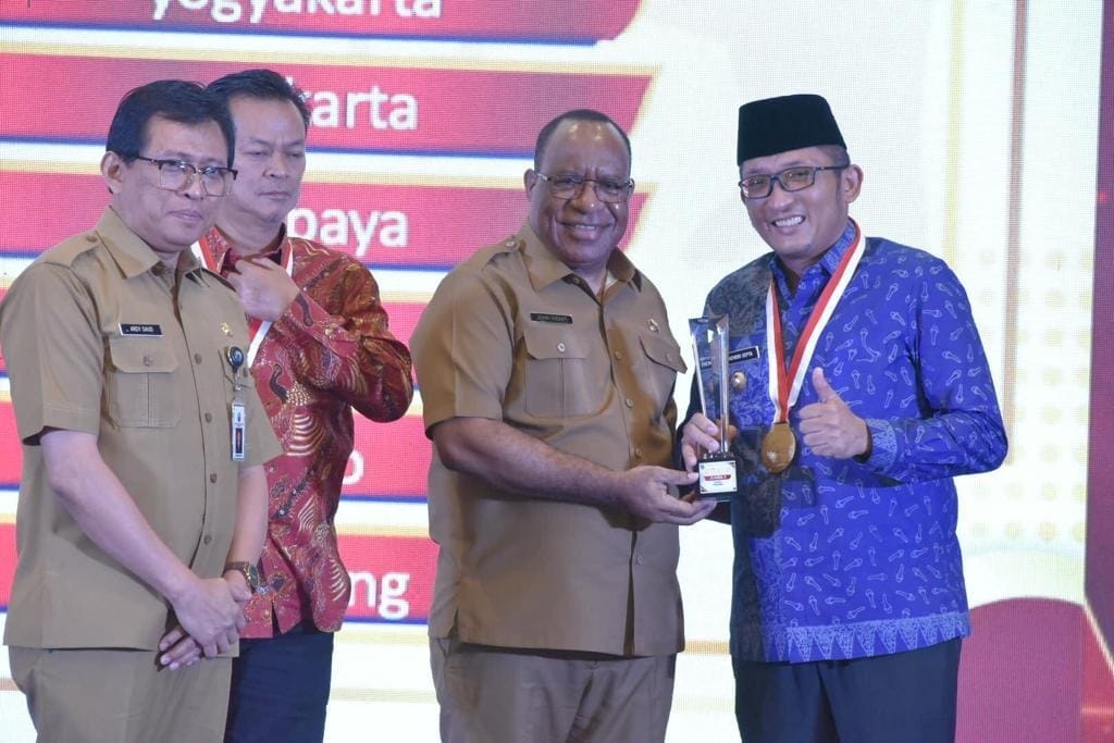 Hendri Septa menerima penghargaan atas penerapan standar pelayanan minimal (SPM) terbaik II se-Indonesia diserahkan oleh Wamendagri RI John Wempi Wetipo. (Tandri/Padek)