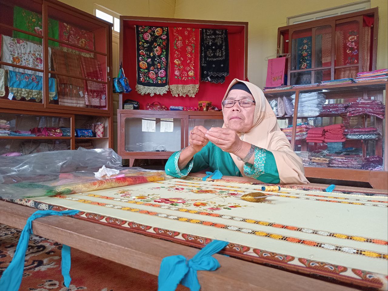 SEORANG pengrajin sedang menyelesaikan sebuah sulaman di Pusat Kerajinan Amai Setia, Nagari Kotogadang, Kecamatan IV Koto, Agam. (RIAN/PADEK)