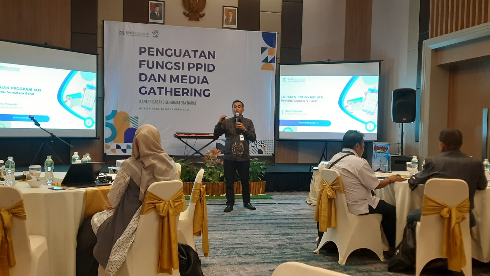 PAPARAN: Kepala BPJS Kesehatan Cabang Bukittinggi Haris Prayudi memaparkan capaian UHC Sumbar di Hotel Santika Bukittinggi, Senin (18/11).( RIAN AFDOL/PADEK)