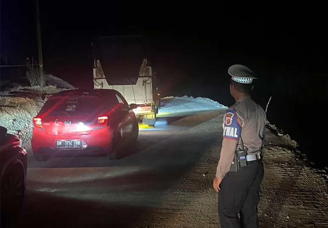 Personel Polres Kampar mengatur arus lalu lintas di jalan lintas Riau-Sumbar Km 106/107 Desa Tanjung Alai Kecamatan XIII Koto Kampar, Selasa (25/11/2024). (Humas Polres Kampar/ Riau Pos)