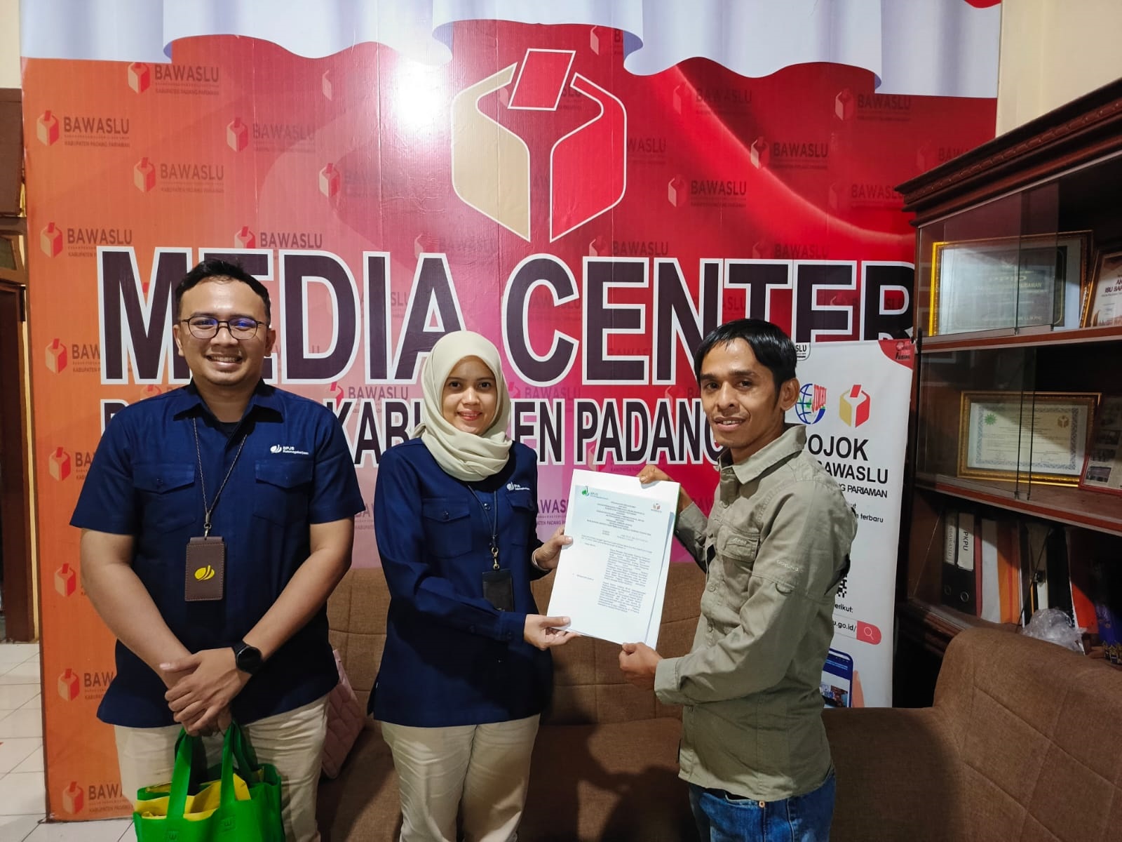SINERGI: Anggota Bawaslu Padangpariaman, Indra Gunawan, dan perwakilan BPJS Ketenagakerjaan Padang memegang lembaran kerja samanya, baru-baru ini.(DOK BAWASLU PADANGPARIAMAN)
