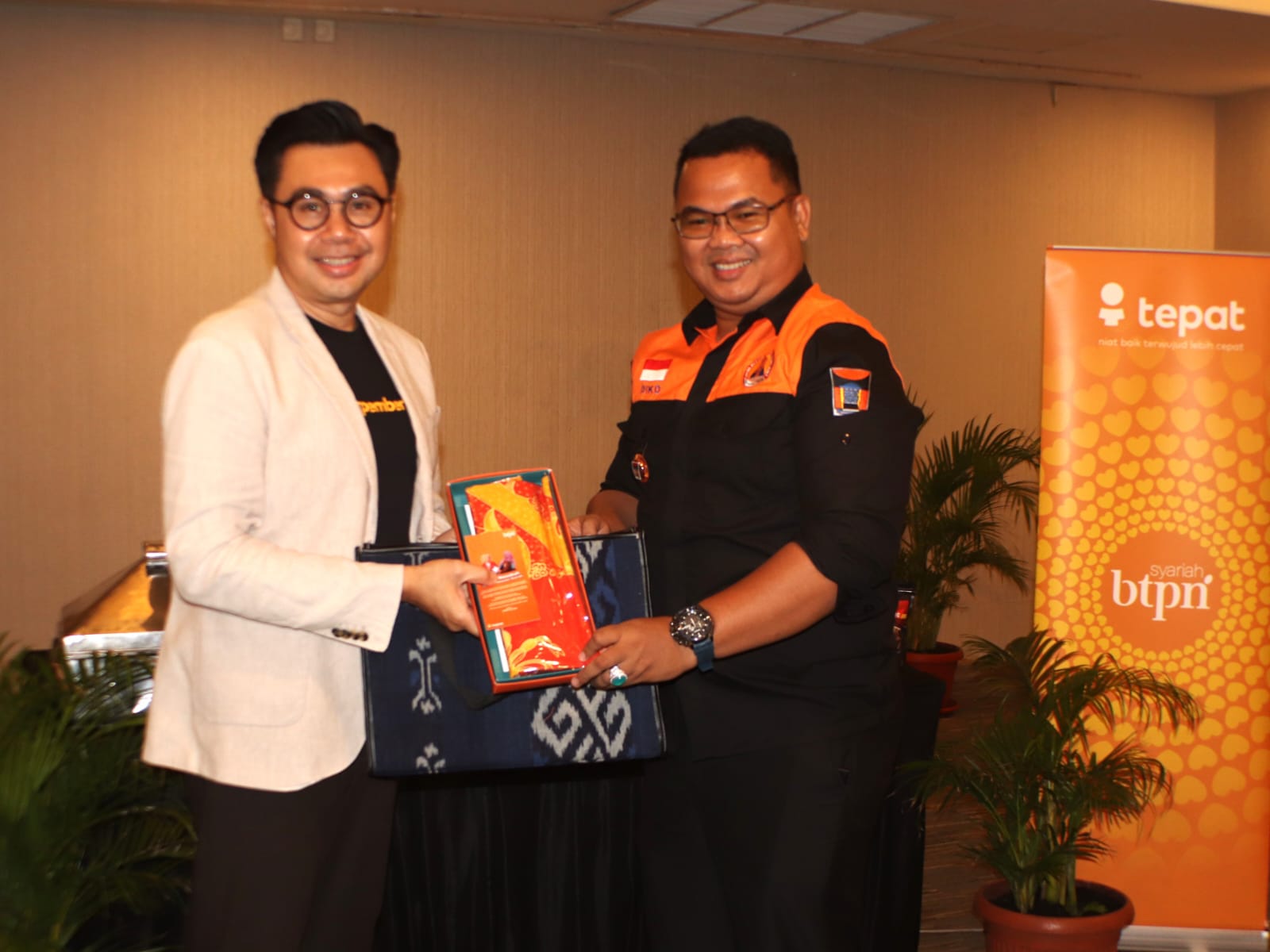 Corporate & Marketing Communication Head BTPN Syariah Ainul Yaqin menyerahkan cenderamata kepada Camat Padang Timur Diko Eka Putra .