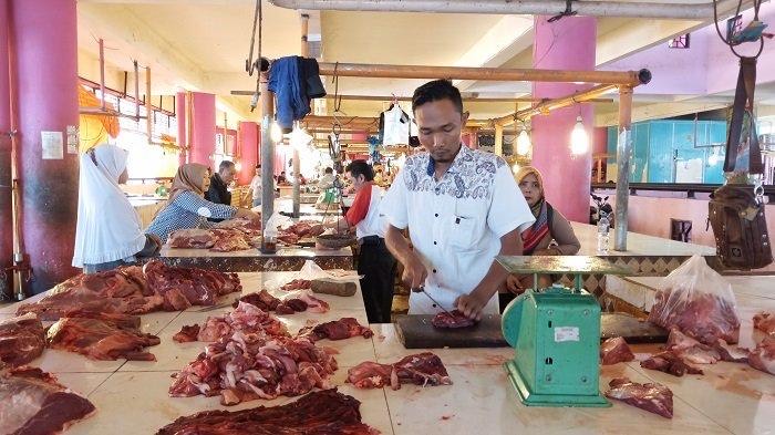 Salah seorang pedagang daging di Pasar Raya Padang sedang melayani pembeli, Selasa (10/12).
