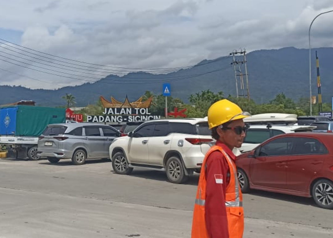 Petugas mengatur antrean kendaraan masyarakat yang antusias ingin mencoba melintasi tol Padang Sicincin, Minggu (15/12/2024). (Foto: Heri Sugiarto/Padek)