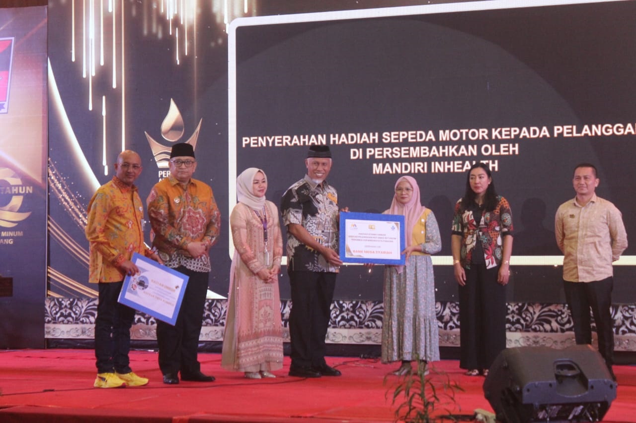 Gubernur Sumbar Mahyeldi Ansharullah menyerahkan simbolis hadiah kepada seorang pelanggan setia Perumda Air Minum Kota Padang saat acara puncak HUT ke-50 di Hotel Truntum Padang.
