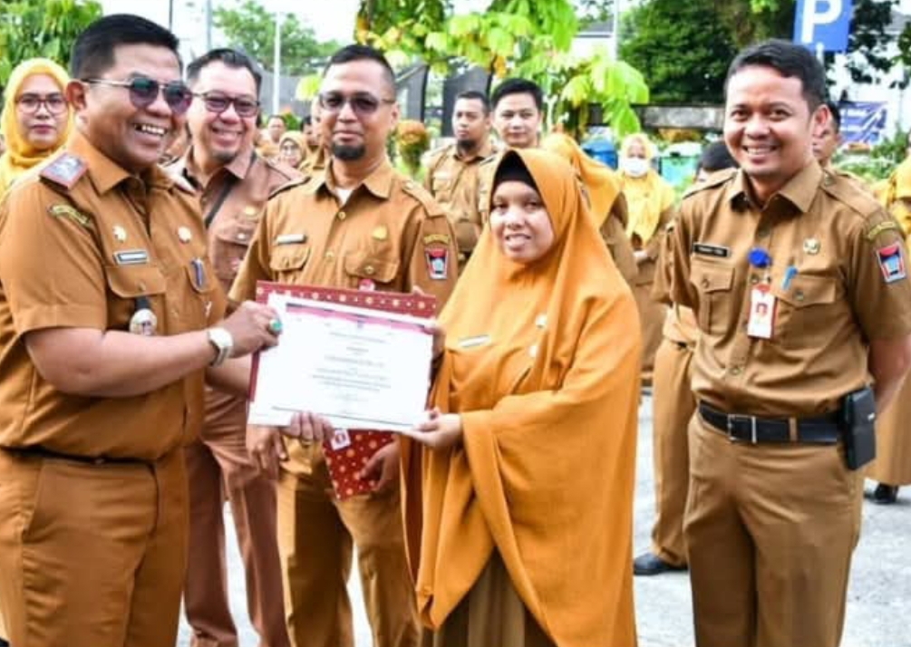 Penjabat Sekda Kota Padang, Yosefriawan, menyerahkan Penghargaan Employee of The 2nd Semester 2024 kepada ASN dengan kinerja terbaik. (Foto: Prokopim)