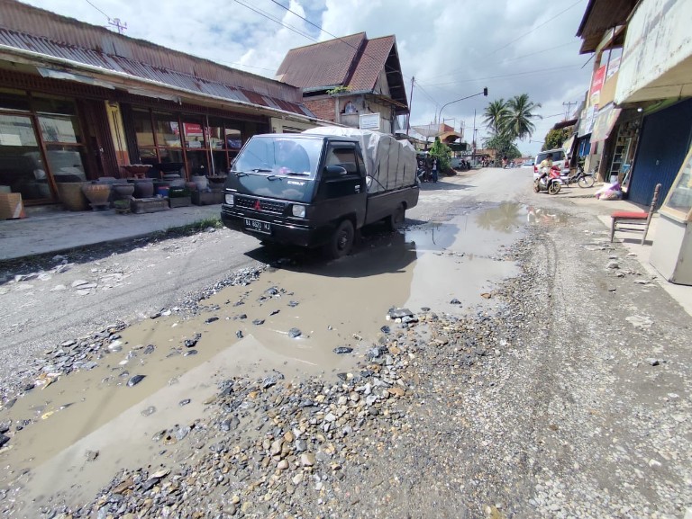 BUTUH PENANGANAN CEPAT: Sebuah mobil pikap melewati jalan rusak parah di ruas Jalan Raya Payakumbuh-Lintau, kemarin.(SY RIDWAN/PADEK)