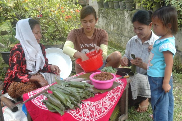 MASIH BERTAHAN: Pelaku usaha kuliner tradisional putu kambang Yarnis saat melayani pembeli, kemarin.(YONI SYAFRIZAL/PADEK)