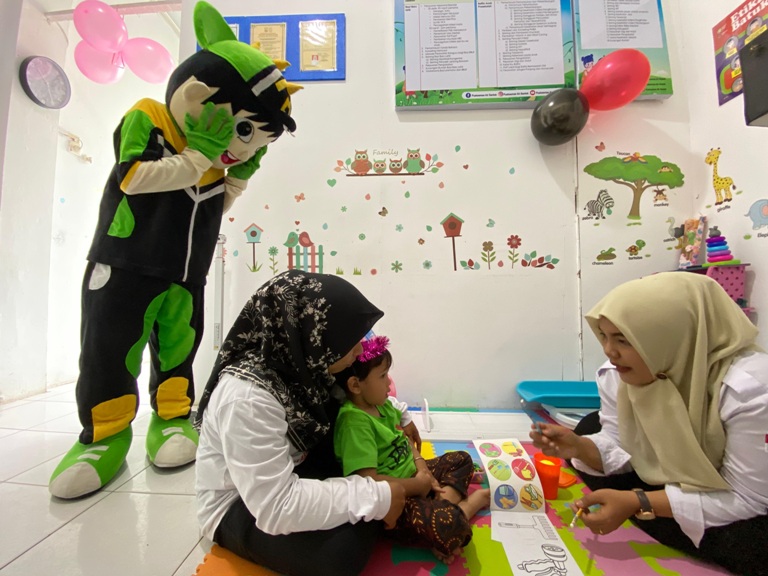 DIBUAT SEMENARIK MUNGKIN: Seorang anak mendapat pelayanan Cek Kesehatan Gratis di Puskesmas Santok, Pariaman, kemarin. Puskesmas ini menyediakan badut untuk menarik minat anak-anak.(ZIKRINIATI/PADEK)