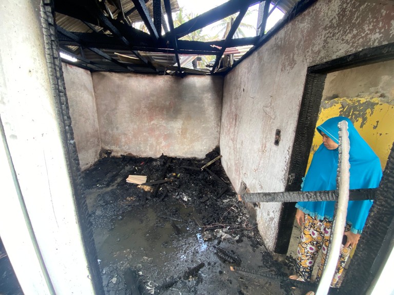 BERSEDIH: Ezif Marini, berdiri di depan rumah kontrakan yang terbakar di Jorong Subarang Parik, Kenagarian Koto Tangah Batu Hampa, Kecamatan Akabiluru, Kabupaten Limapuluh Kota.(SY RIDWAN/PADEK)