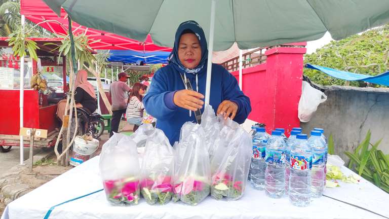 Seorang pedagang bunga rampai Teti, di TPU Tunggul Hitam saat menata dagangannya, Minggu (23/2/2025) sore. (Randi/Padek)