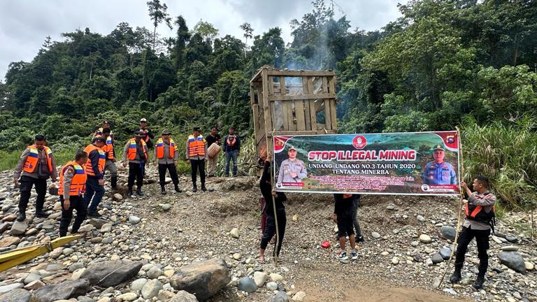 TINDAKAN: Kapolres Solsel AKBP Muhammad Faisal Perdana dan jajarannya membakar peralatan bekas tambang emas ilegal dan memasang spanduk imbauan di kawasan sungai.(HUMAS POLRES SOLSEL FOR PADEK)