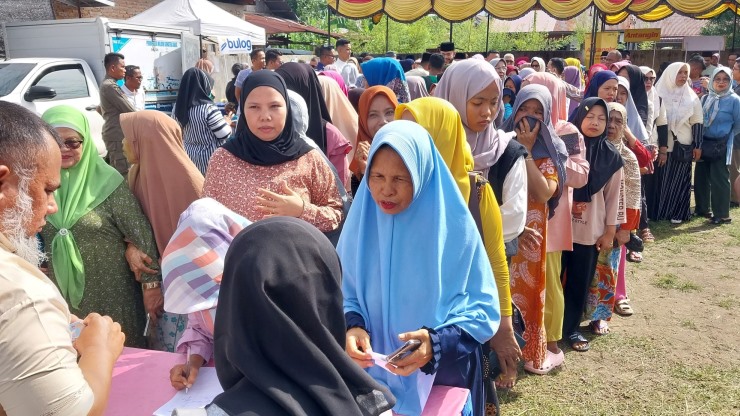 Ibu-ibu warga Dadok Tunggul Hitam antri mendapatkan kupon voucher senilai Rp5000 di Pasar Murah yang digelar Disdag Padang, Selasa (4/3/2025).