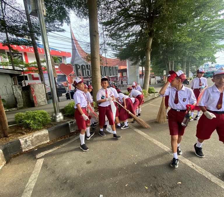 BERSEMANGAT: Para murid SD Pius Payakumbuh melakukan gotong royong bersama membersihkan lingkungan. (TIM LAMAN GURUR)