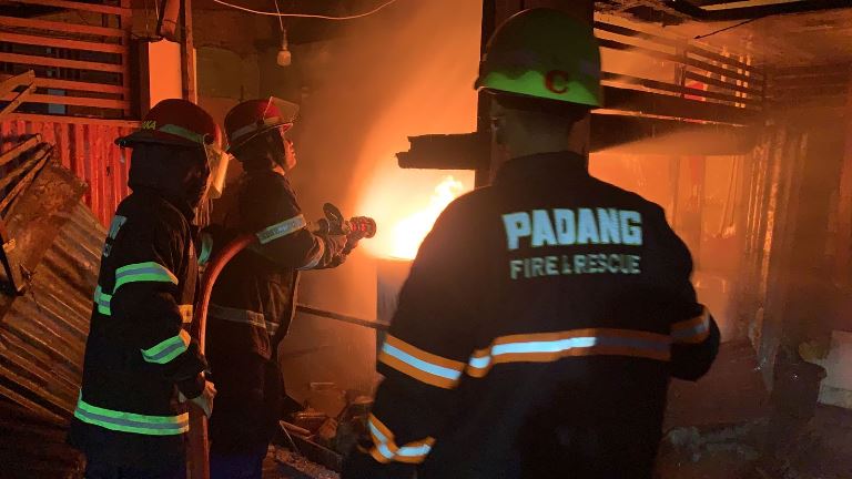 Petugas memadamkan api yang membakar rumah di kawasan Jati Gaung No. 175, Kelurahan Jati, Kecamatan Padang Timur, Kota Padang, Minggu (16/3/2025) malam. (Dinas Damkar Padang)