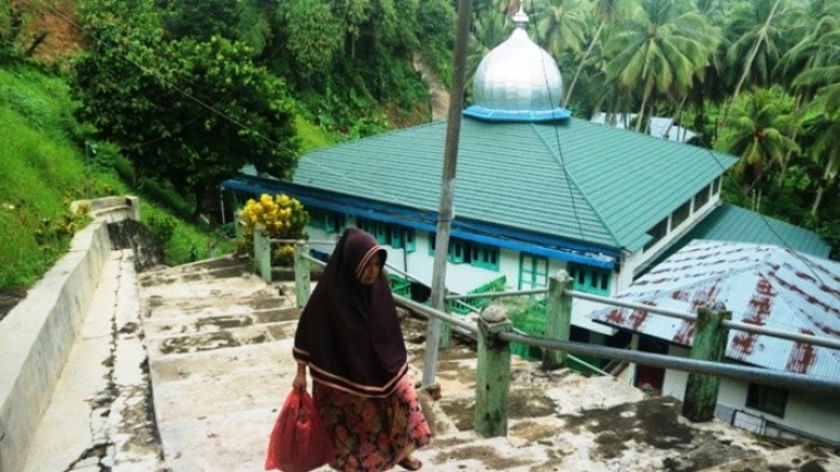 TURUNI TANGGA: Seorang pengunjung terlihat sedang menyusuri anak tangga Masjid Jami&rsquo; yang terletak di Jorong Kapalokoto, Nagari Padangsibusuk, Kecamatan Kupitan,  Sijunjung.(YULICEF ANTHONY/PADEK)