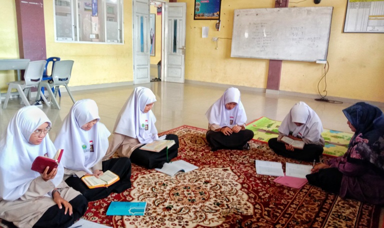 SEMANGAT: Para siswi tengah menyetor hafalan kepada guru. (TIM LAMAN GURU)