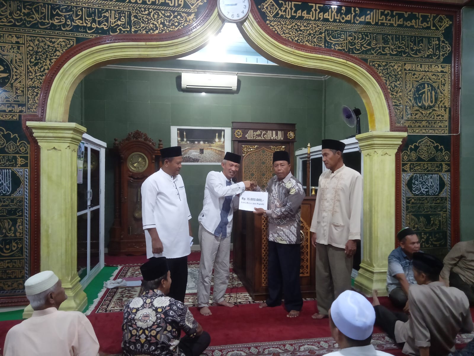 Sekkab Pessel, Mawardi Roska menyerahkan bantuan kepada Pengurus Masjid Imaduddin Ampang Pulai, Nofrion Datuak Bandaro Jambak. (dok. yon)