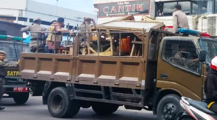 Satpol PP Kota Padang mengangkut dagangan PKL yang berjualan di Jalan Pasar Raya Barat, Jumat (21/3/2025).