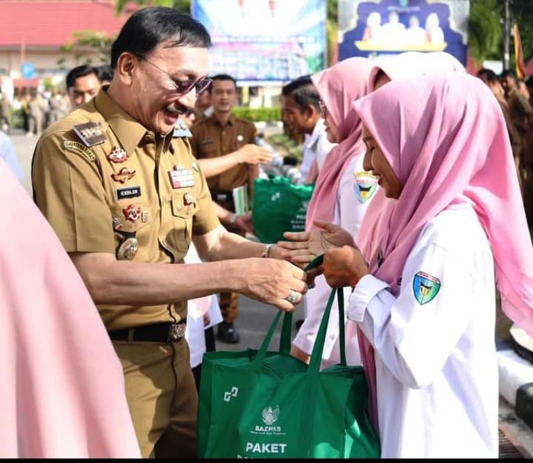 Bupati Pessel, Hendrajoni menyerakan paket Idul Fitri secara simbolis kepada honorer non database. (dok. Kominfo)