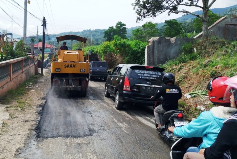HADAPI LEBARAN: Alat berat bekerja merapikan ruas jalan Manggopoh-Padanglua, kemarin.(BIRO ADPIM UNTUK PADEK)