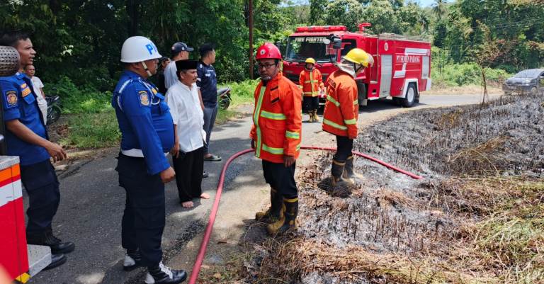 Petugas Dinas Damkar Kota Padang memadamkan api yang membakar lahan seluas 700 meter persegi di Padangbesi, Kota Padang, Selasa (1/4/2025) siang. (Dinas Damkar Kota Padang)