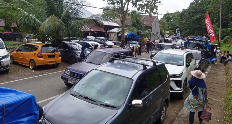 Mobil pengunjung memadati pinggir jalan di salah satu areal parkir milik pribadi  di kawasan wisata Pantai Carocok Painan. (Foto: Yoni Syafrizal/Padeks)