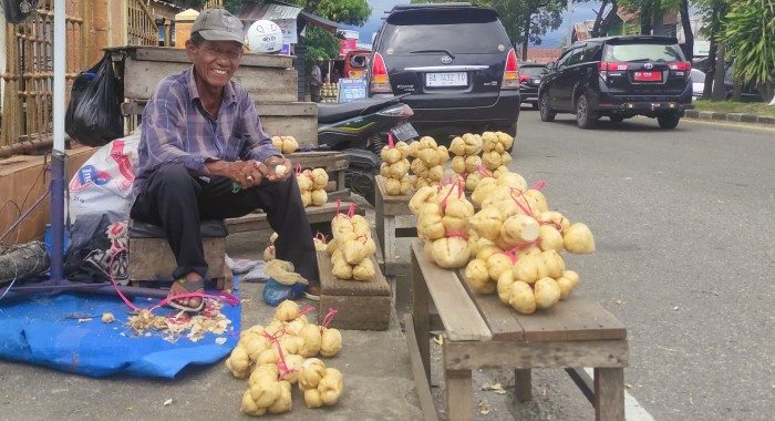 Waju, salah seorang penjual bengkuang di simpang empat lampu merah Lubuk Begalung, Kota Padang. (foto: faisal kamza/padeks)