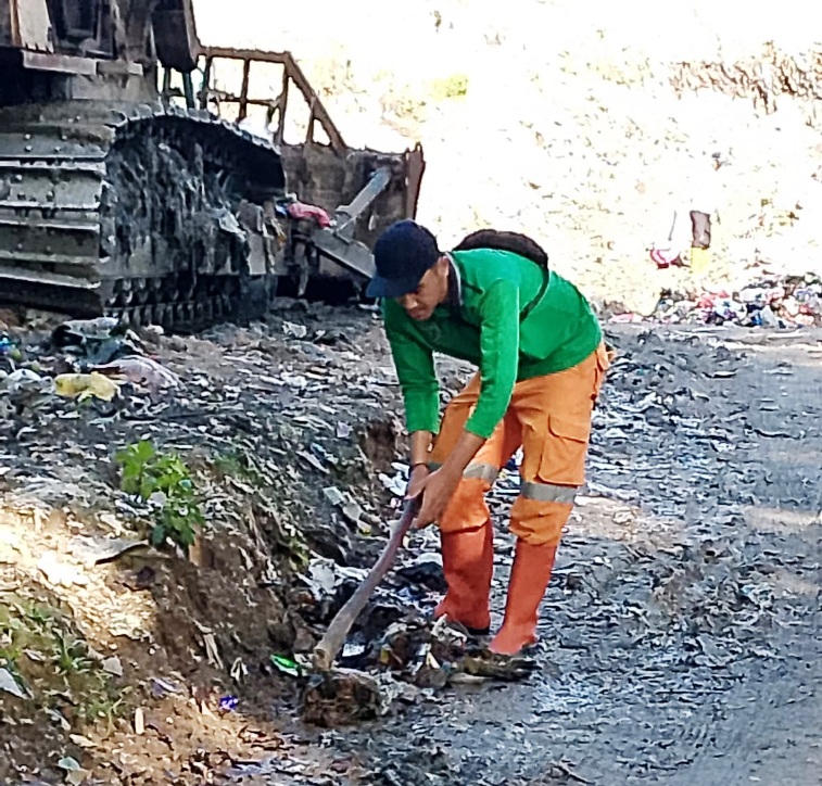 BERSIHKAN SAMPAH: Salah seorang petugas kebersihan sedang membersihkan sampah, baru-baru ini.(DOK DINAS PERKIM LH)